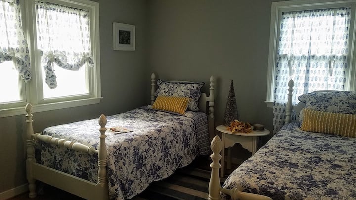 Bedroom #3 The Rustic Marigold features a rocking chair, set of twin beds, chest, and closet.