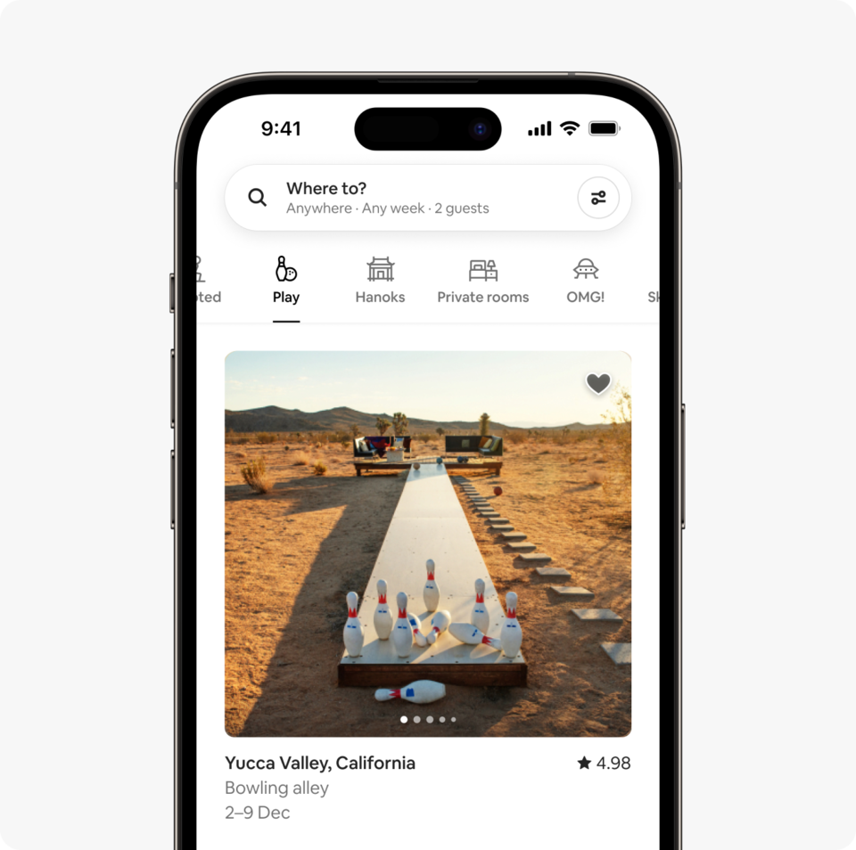 A laptop and a phone show the Airbnb homepage with two rows of homes from a new Airbnb November Release category called Play, which features homes with fun activities like games rooms, water slides, basketball courts and more.