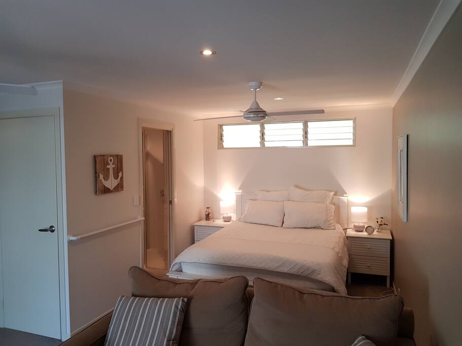 Studio guest room with queen bed (ensuite entry and build in cupboard door on left)