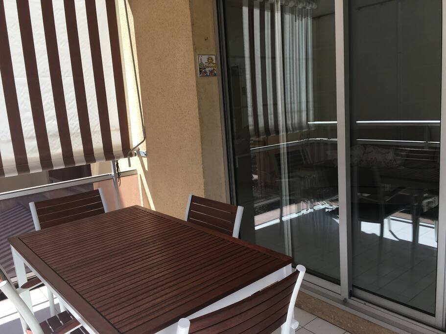 Balcon exposé sud. Stores bannes protégeant du soleil et du vis à vis, Table et chaises pour 4 personnes, parasol et séchoir à linge.