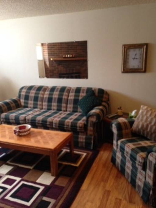 Living area with bright windows, loveseat, sofa and chair for seating