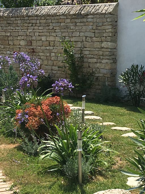 Massif et mur de pierre entrée du jardin