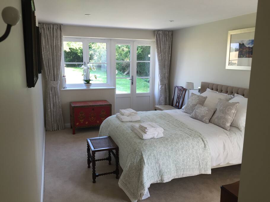 King size bedroom with en suite French doors give access to the patio and garden with table and chairs.