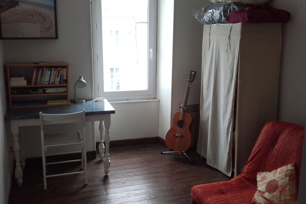 Chambre avec armoire et coin bureau (quelques livres si envie), le futon serait un peu ferme ...