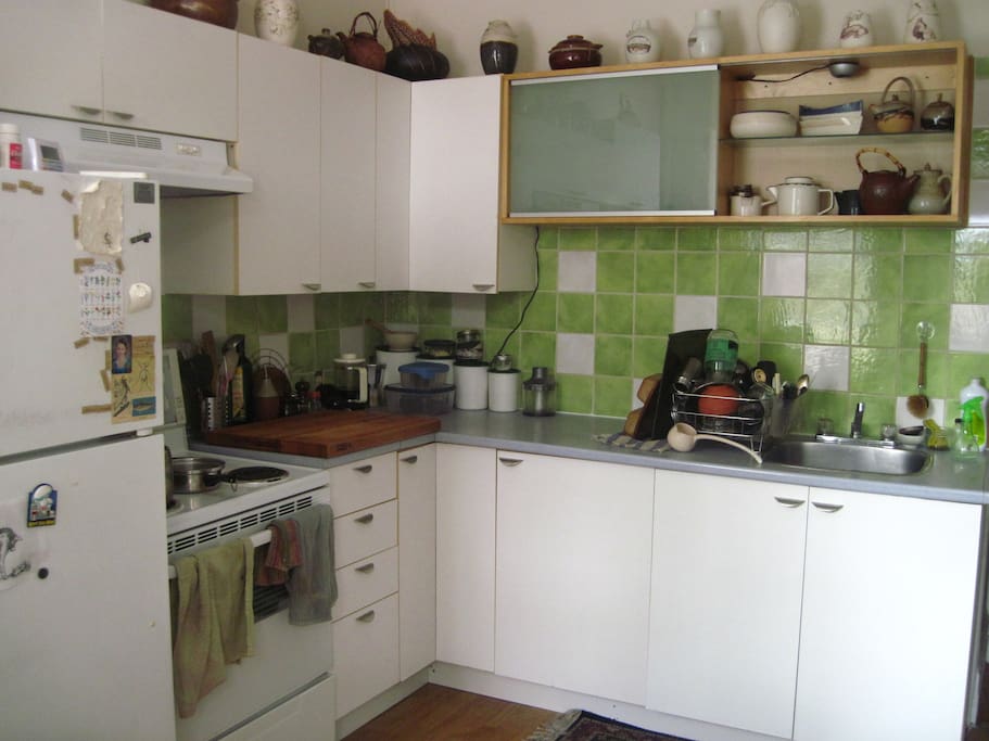 Grande cuisine avec tous les aménagements: four, frigidaire, laveuse, sécheuse, table à manger.