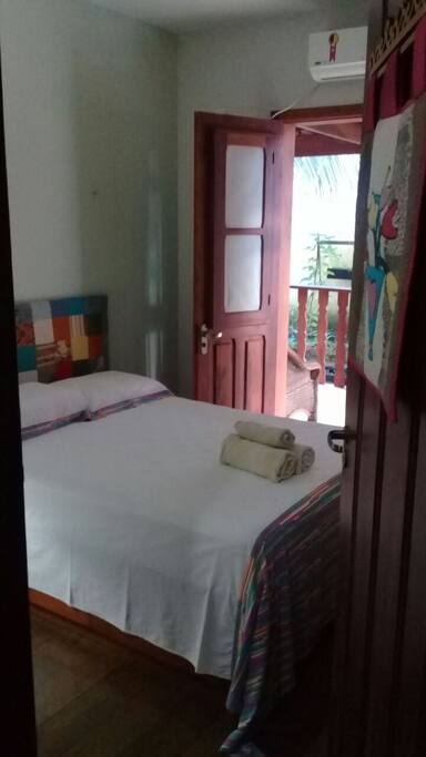 Quarto com cama de casal em colchão de mola.