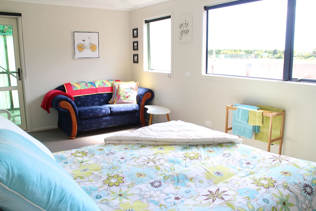 A beautiful sunny a private room with a comfortable Queen sized bed and a two seater sofa for relaxation.