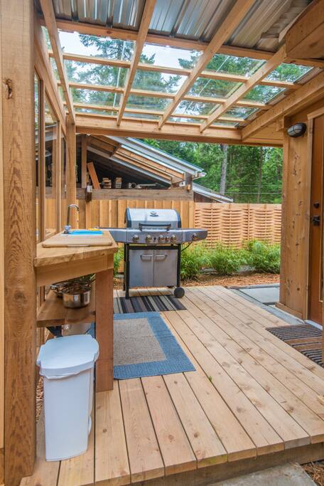 An outdoor cooking area includes a BBQ.