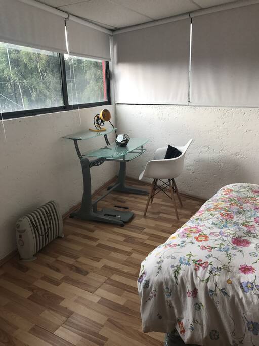 Recámara con escritorio para trabajar y lámpara de escritorio.
