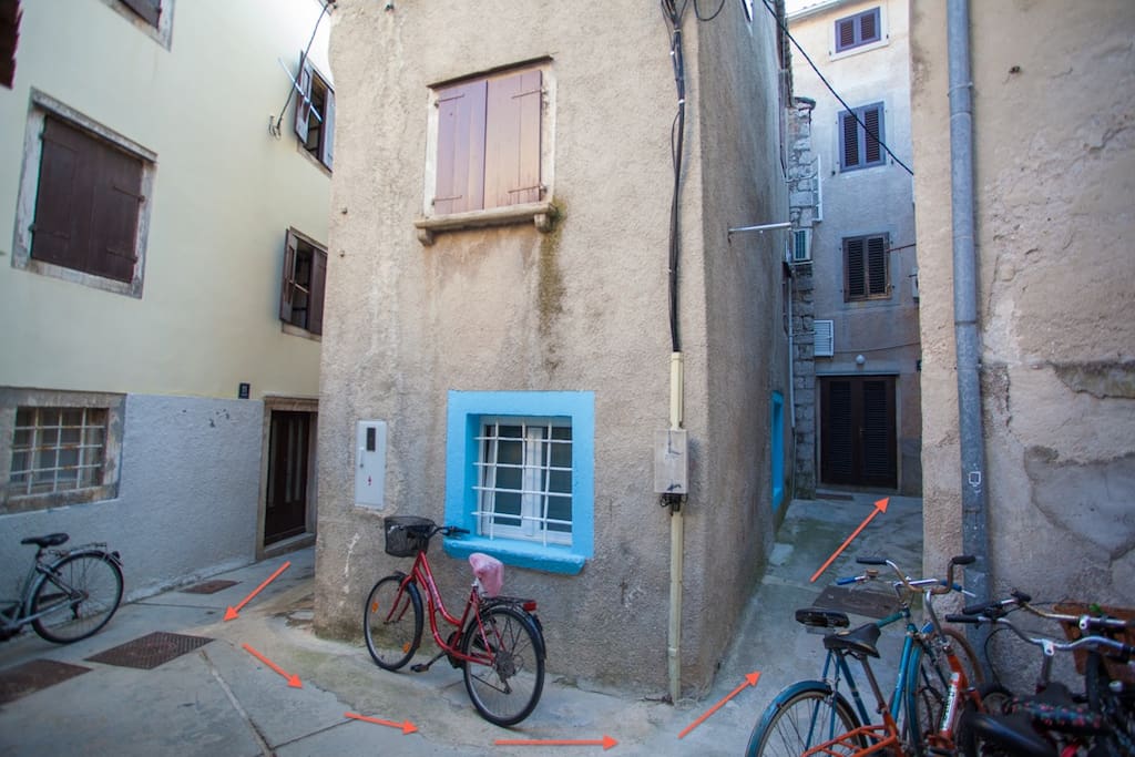 The arrows are pointing to the entrance of the apartment building, and you will be up a couple of flights of stairs