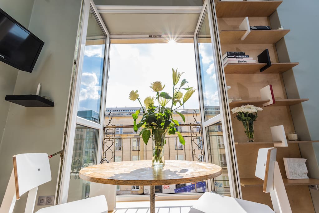 The dining/work area of the studio, adjacent to a balcony window