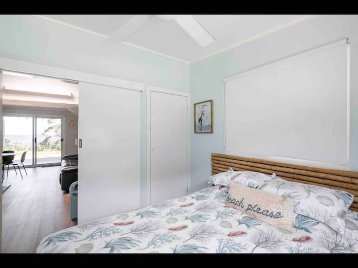 Bedroom downstairs has queen bed and has a closet to hang clothes with a baby/small toddler cot.