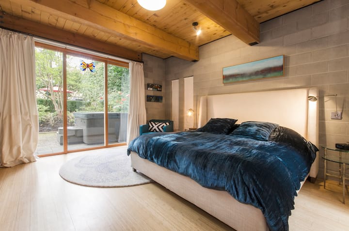 Master bedroom with view to hot tub on outdoor patio.