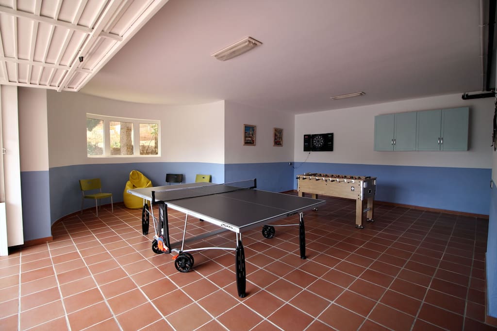 Zona ocio con mesa de ping pong, futbolín y diana de dardos / Leisure area with a tennins table, a football table and a dard board