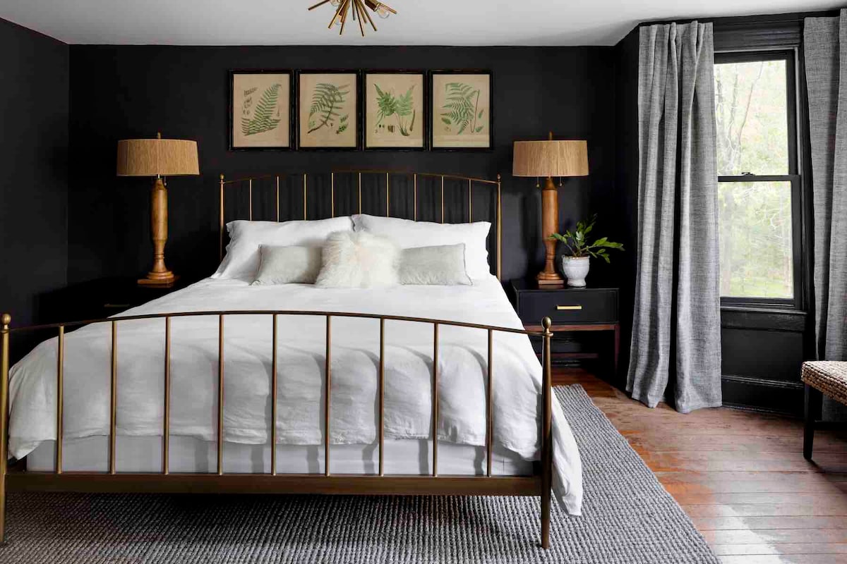 Escape to the elegance of the primary suite, where moody dark walls and a Crate & Barrel king size bed set the tone for your retreat.  Here you'll find our favorite luxury Cozy Earth sheets!