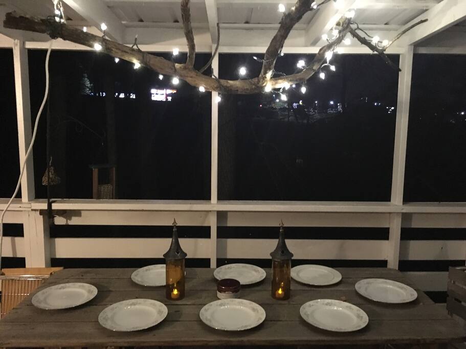 Fallen limb repurposed into a twinkle light chandelier casts a romantic mood.