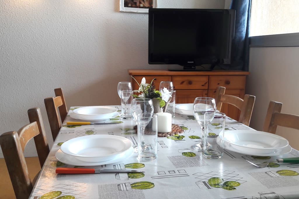 Table à manger avec 4 chaises ainsi qu'une commode et une télévision. Espace agréable face au balcon avec beaucoup de lumière. Le balcon donne directement sur la mer et le port. Vous y trouverez une autre table avec 5 chaises supplémentaires.