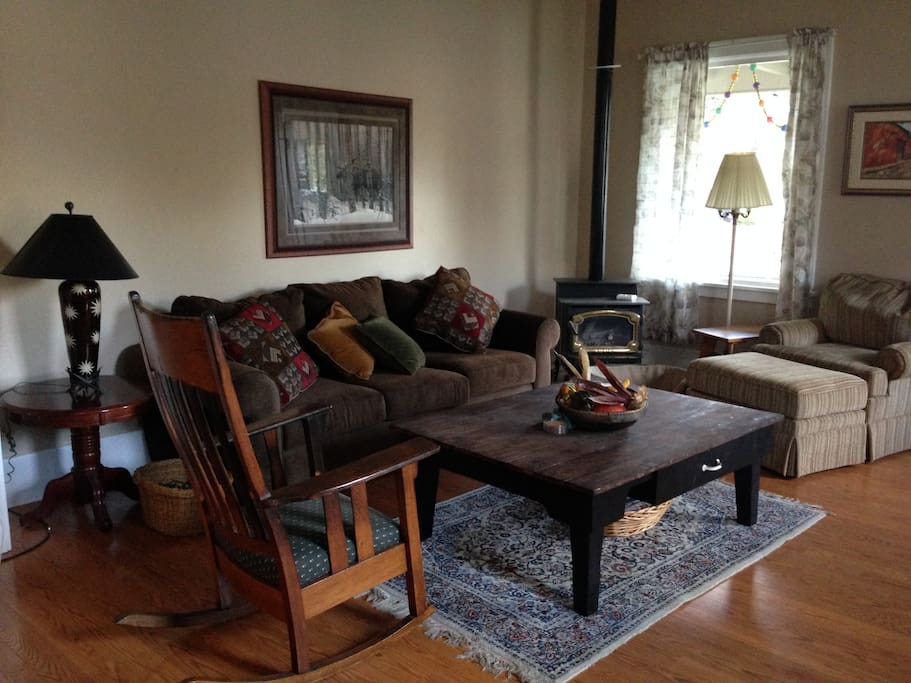 Living room with gas heat stove. Very sunny and inviting.
