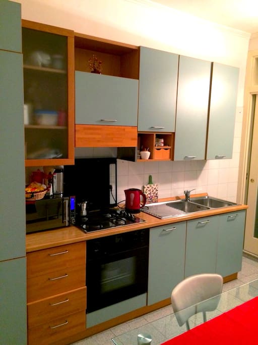 cucina attrezzata con frigorifero, forno, microonde, bollitore, macchina da caffè