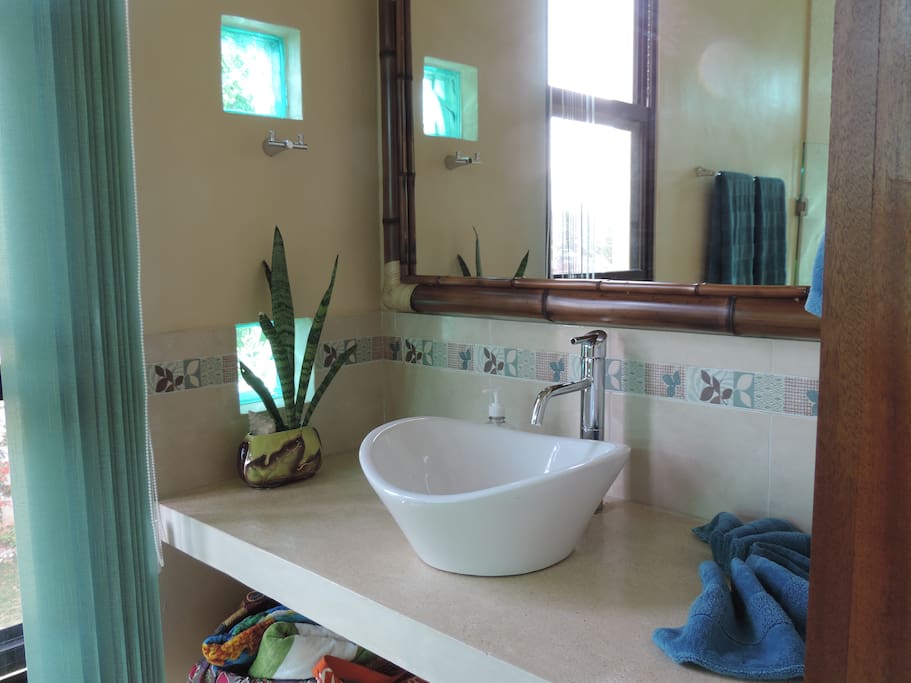 Large bath with oversized bamboo mirror.