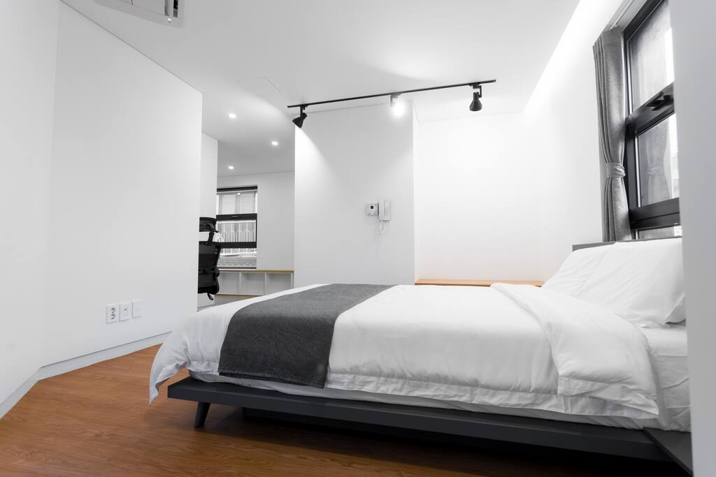 Each room features a comfy queen bed, work space, closet, balcony, and a bathroom.