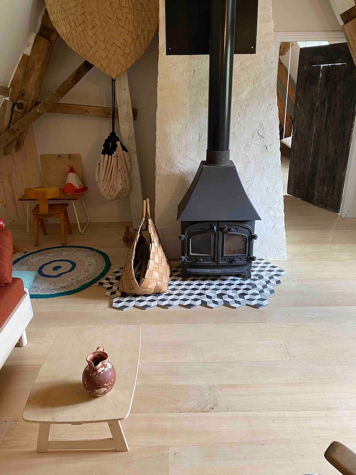 موقد يعمل بالحطب في غرفة المعيشة ومنطقة لعب الأطفال.