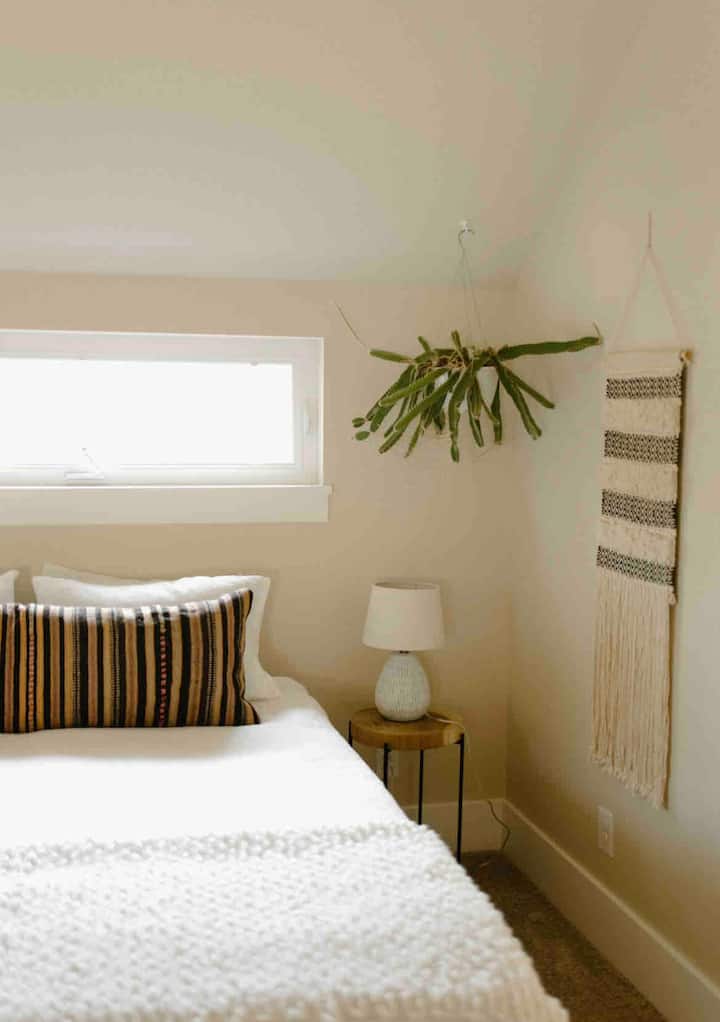 Queen bedroom featuring a delightful, new foam mattress and cathedral ceilings with a spacious closet and a full size bathroom with shower + tub just outside of the room. 