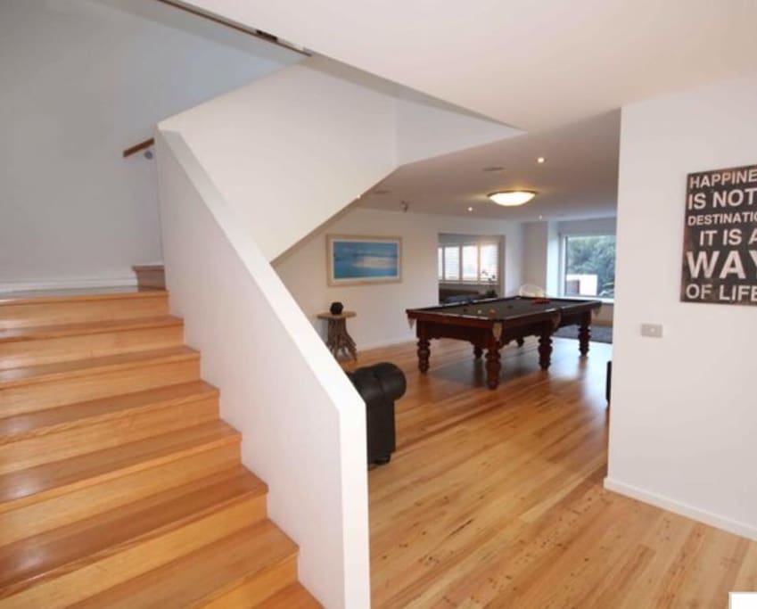 Stairway to second level, large billiard room with three quarter size table and sofas. There is a table tennis top that fits the table top.