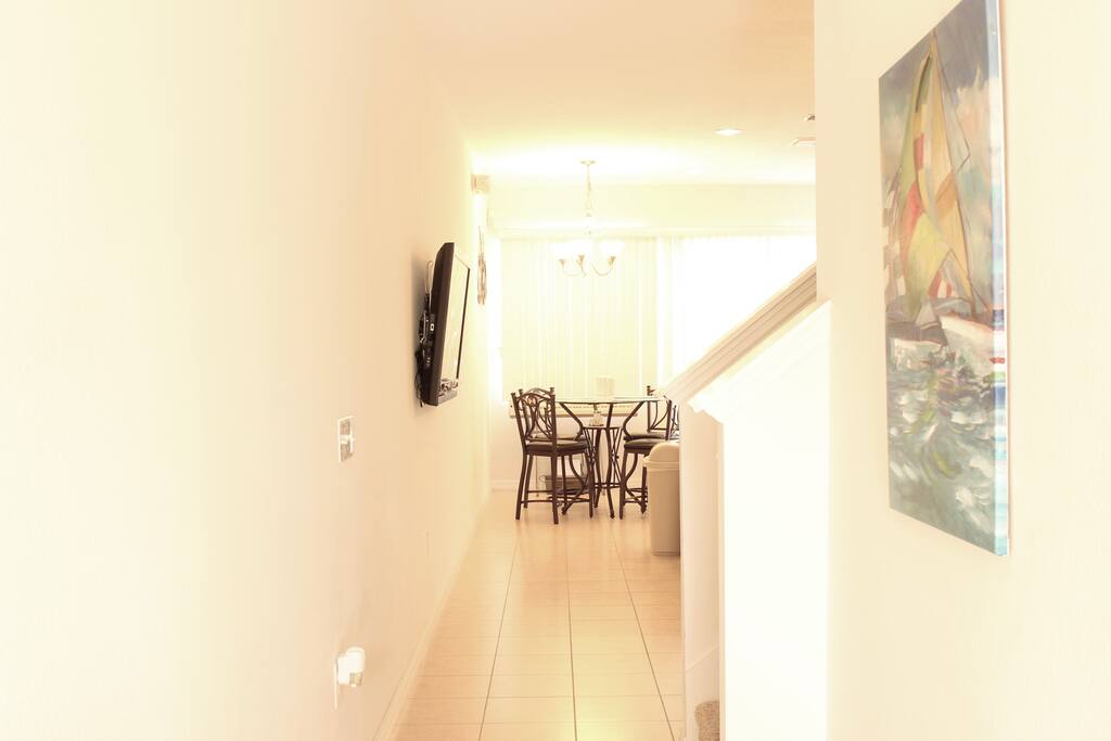 The entryway leads to the bedroom and bathroom on the right and the living room, dining, and kitchen areas ahead.