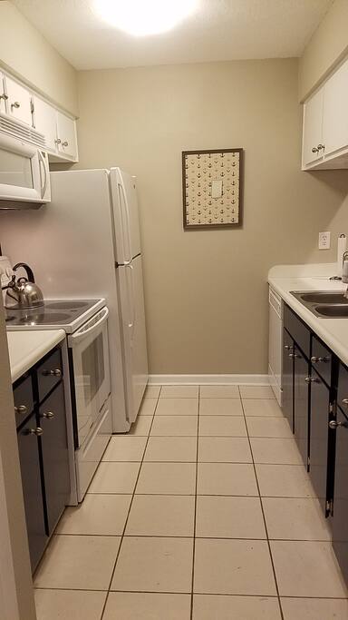 Full kitchen stocked with dishes and cookware.