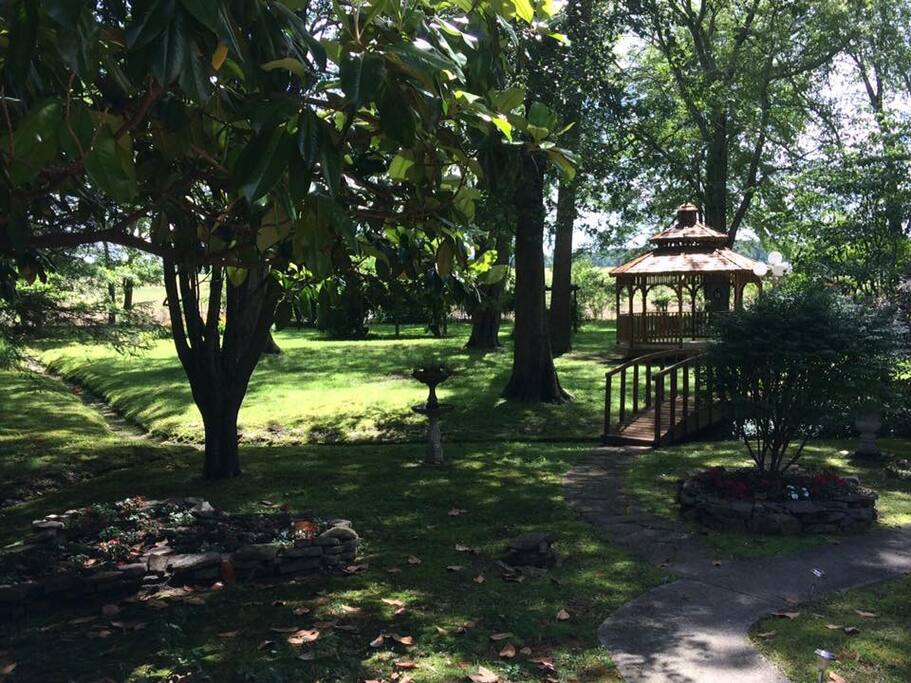 The back yard has lots of trees and a gazebo with swing chairs and a hammock to enjoy some chill time.