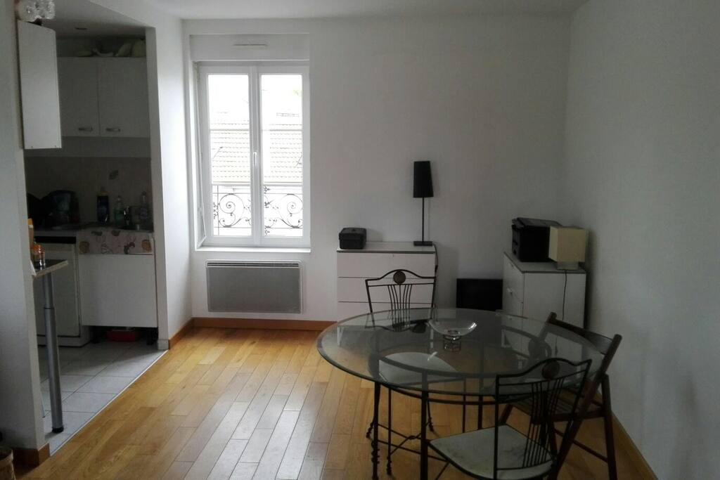 photo du salon avec fênetre donnant sur cour. A gauche, la cuisine