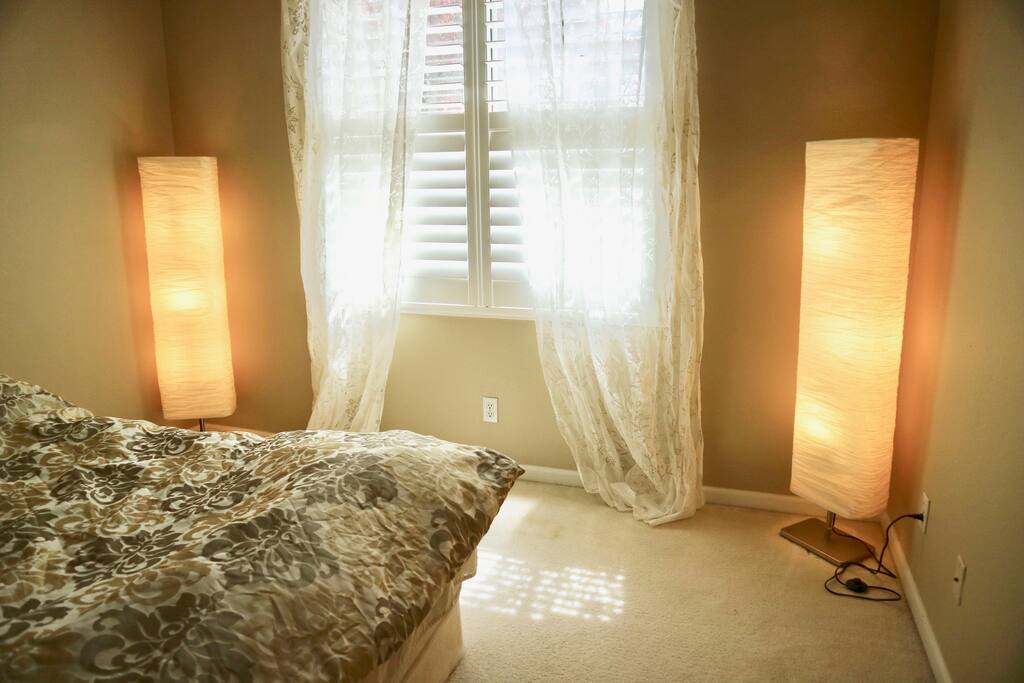 Sunlight goes though the blinds, with flowery curtains
