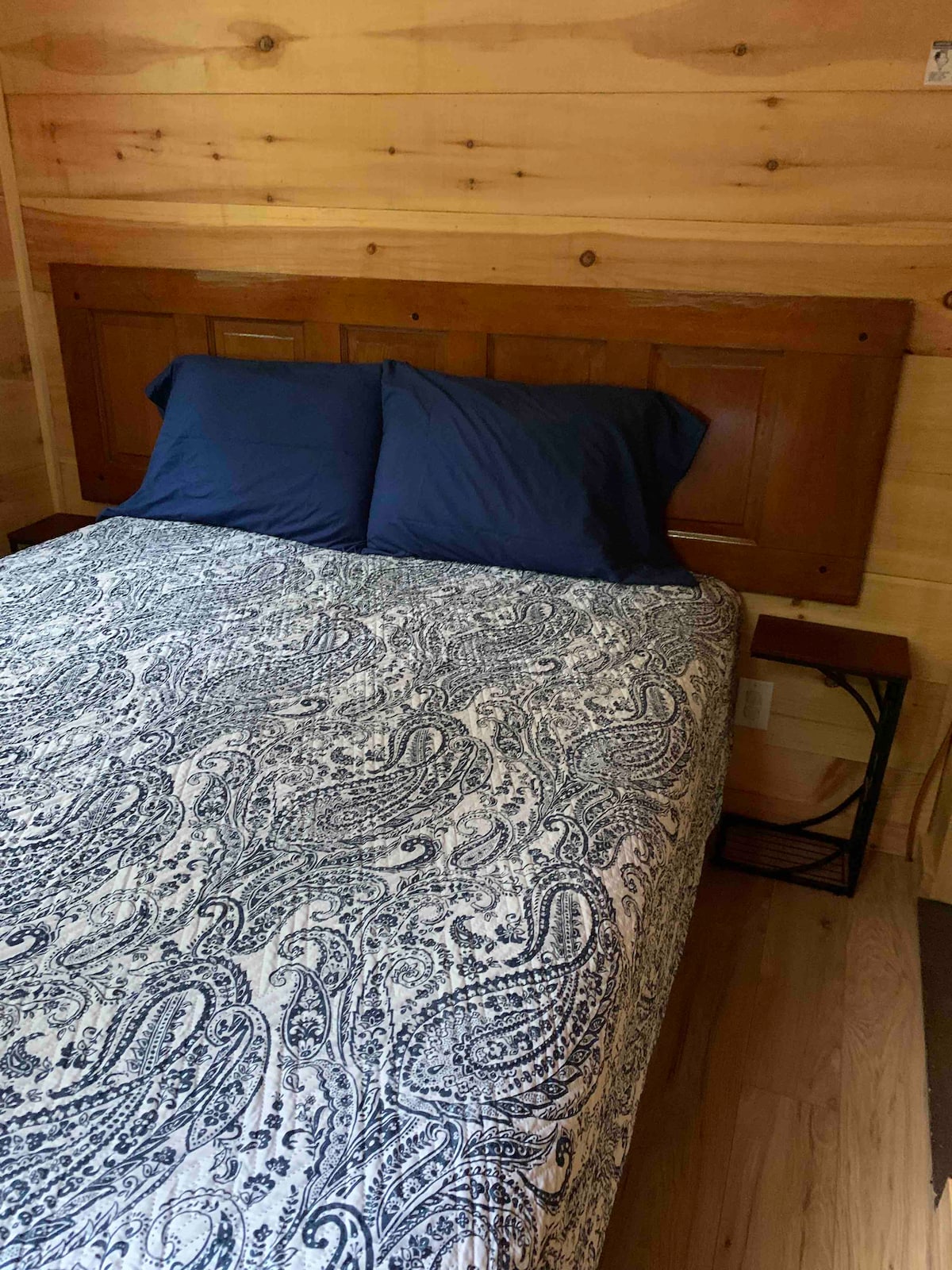 غرفة النوم الرئيسية بسرير كبير وطاولات جانبية