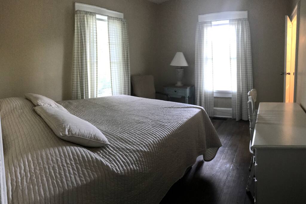 First bedroom with a queen bed, desk and 1/2 bath.