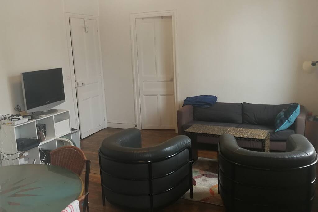 Autre partie du salon avec TV et fauteuils