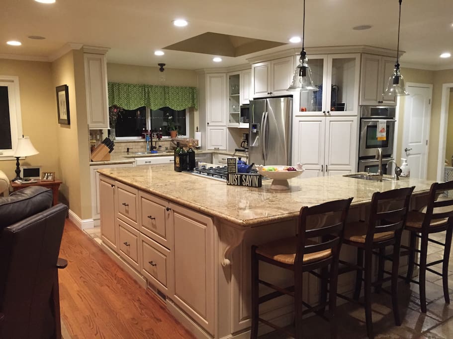 New kitchen with double ovens, granite countertops and stainless steel appliances.