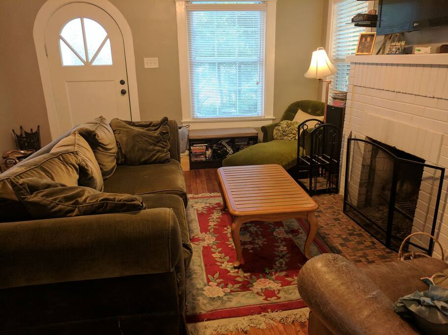 Main living area with wood fireplace, TV, and multiple game consoles.
