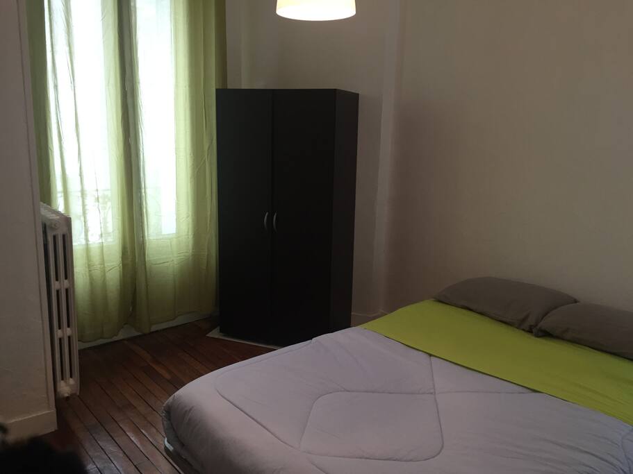 La première chambre avec placard de rangement et linge de maison