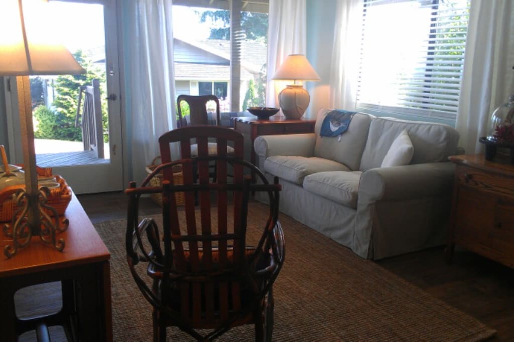 Living room area with bed to the left and kitchen behind photographer.