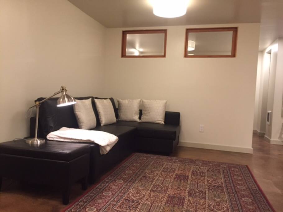 L-shaped couch with extra blanket in storage compartment.