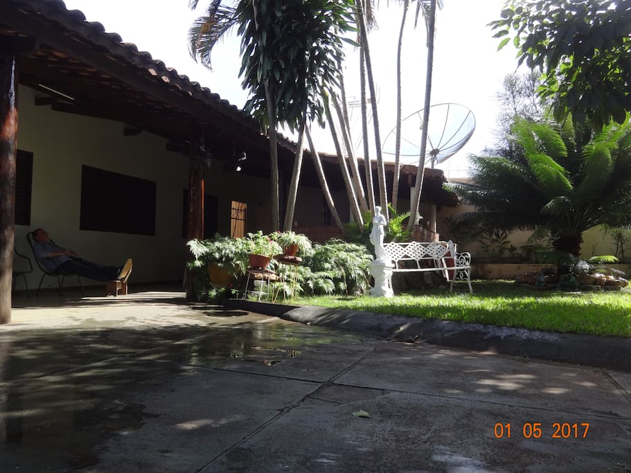 Varanda externa e banco de jardim.