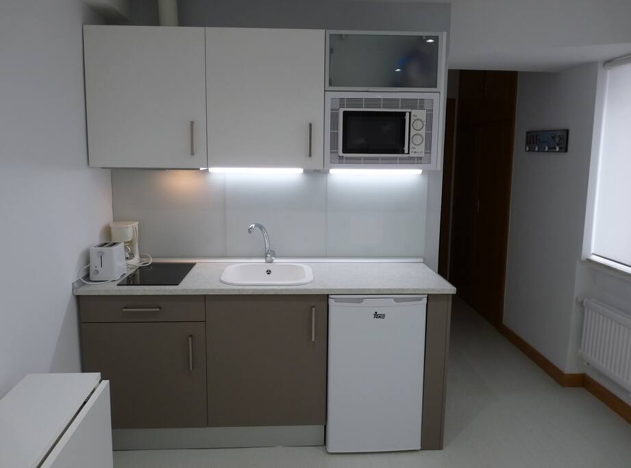 Cocina nueva con microondas, vitrocerámica, nevera. Mesa plegable para 4 personas.