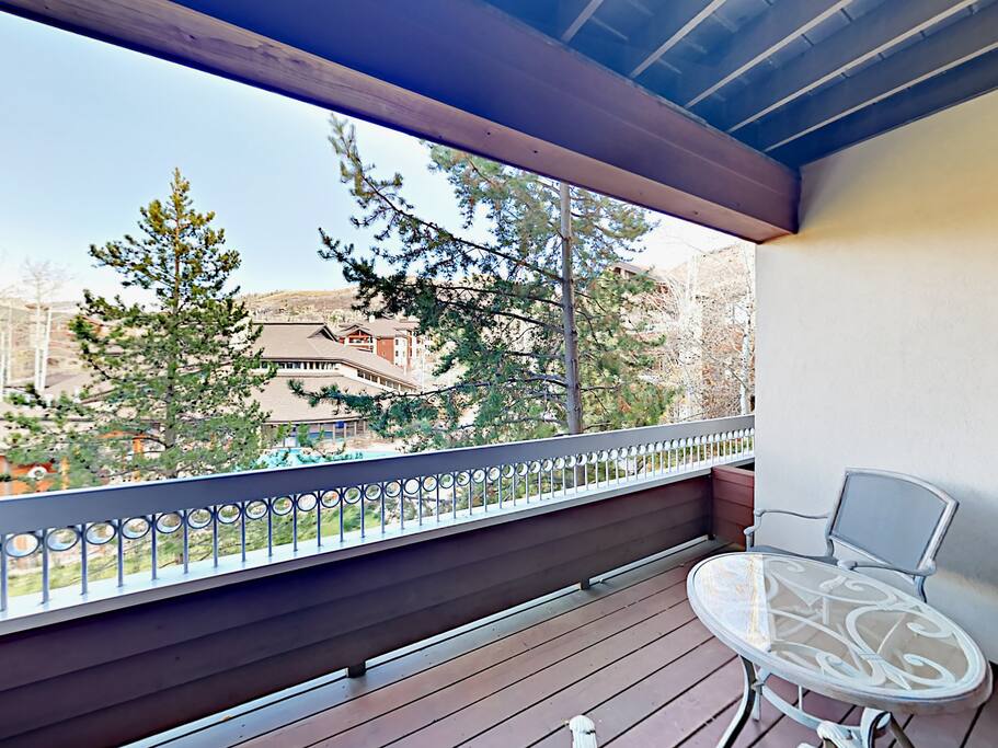 Private balcony overlooking the pool and clubhouse, with mountains beyond. Condo professionally managed and maintained by TurnKey Vacation Rentals.