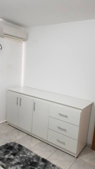 Quarto de casal com com cômoda e ar condicionado.