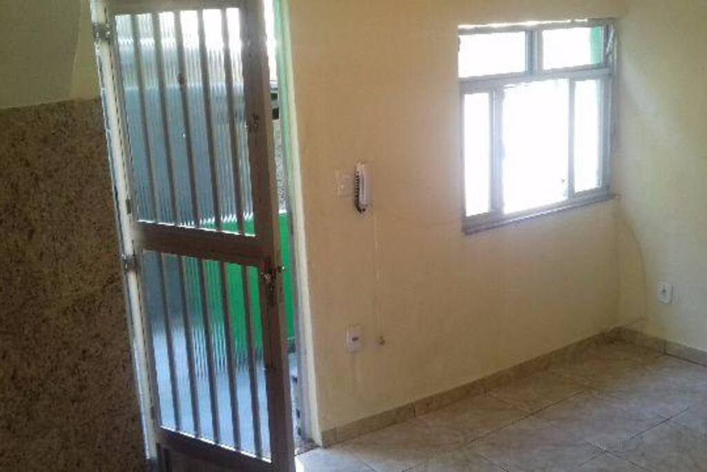 Sala equipada com cômoda, tv, sofá, ventilador e 1 colchão de casal mais um de solteiro