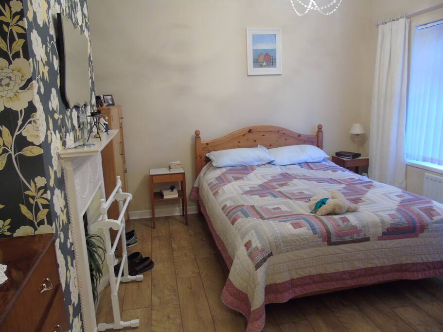Main double bedroom with comfy double bed, feature fireplace, bay window and views of the sea.