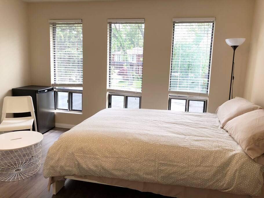 Furnished room with fresh linens, mini refrigerator, tea table, built-in closet, and night stand