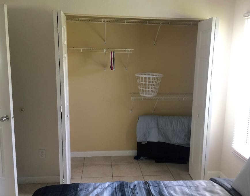 Large closet with hangers and laundry basket.