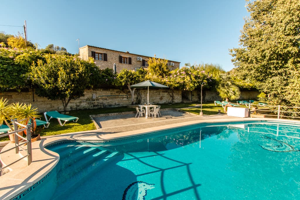 vista de la piscina y la fachada principal de la casa